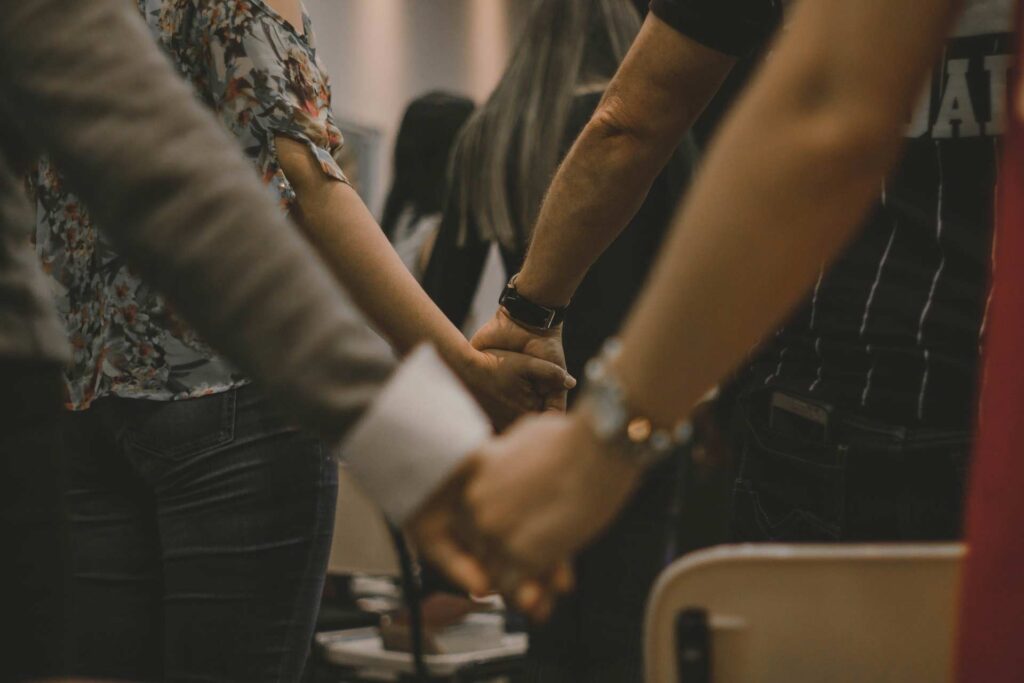 Several people standing and holding hands during church service